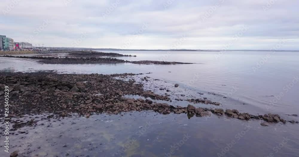 Damaged rocky remains of Galway Promenade with birds flying, drone shot Damaged rocky remains of Galway Promenade with birds flying, drone shot
