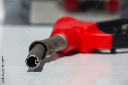 Gasoline pistol pump fuel nozzle Gas station pump. Man refueling gasoline with fuel in a car, holding a nozzle. Limited depth of field.