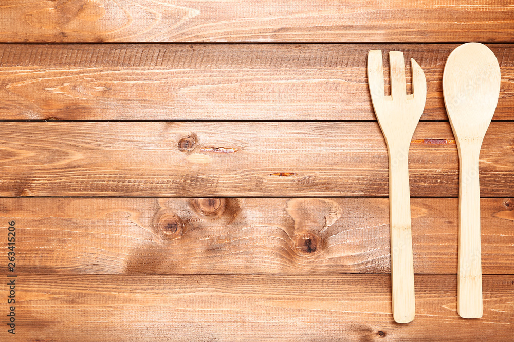 Wooden kitchen cutlery on brown table Wooden kitchen cutlery on brown table