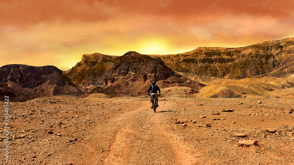 Mountain biker at sunset in a desert Mountain biker at sunset in a desert