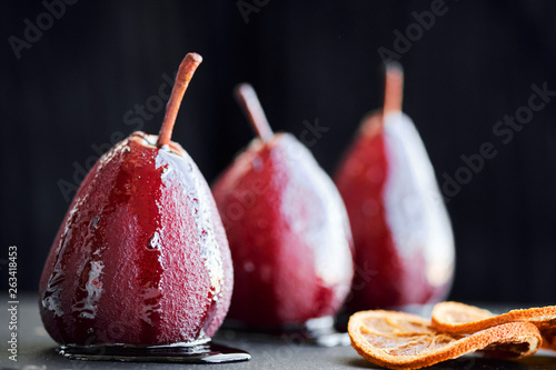 Pears in red wine isolated on black background