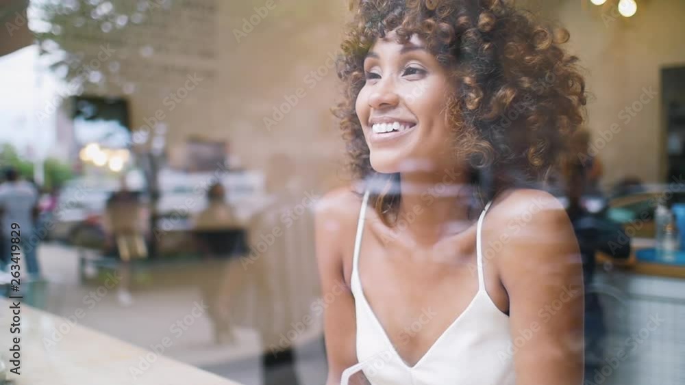 Beautiful american woman in a cafe, view through the glass window Beautiful american woman in a cafe, view through the glass window