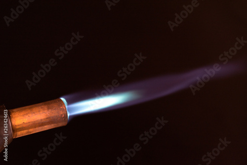 blowtorch blue flame close up dark background
