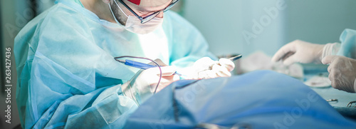 Young male plastic surgeon operates in the operating room of a medical center. photo