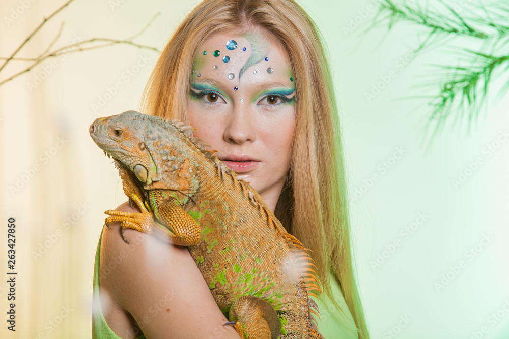 Wild animal in the hands of man. A girl with an unusual makeup with an