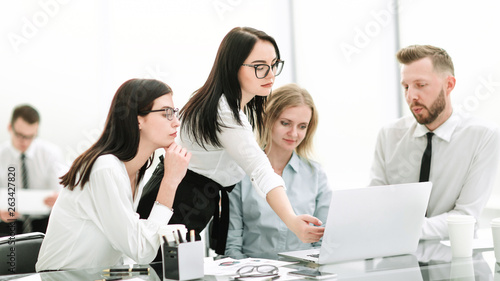 businesswoman pointing to the laptop screen during a meeting with the business team