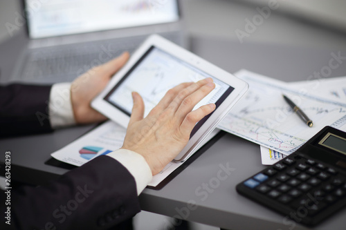 close up.the businessman uses a digital tablet to work with financial data