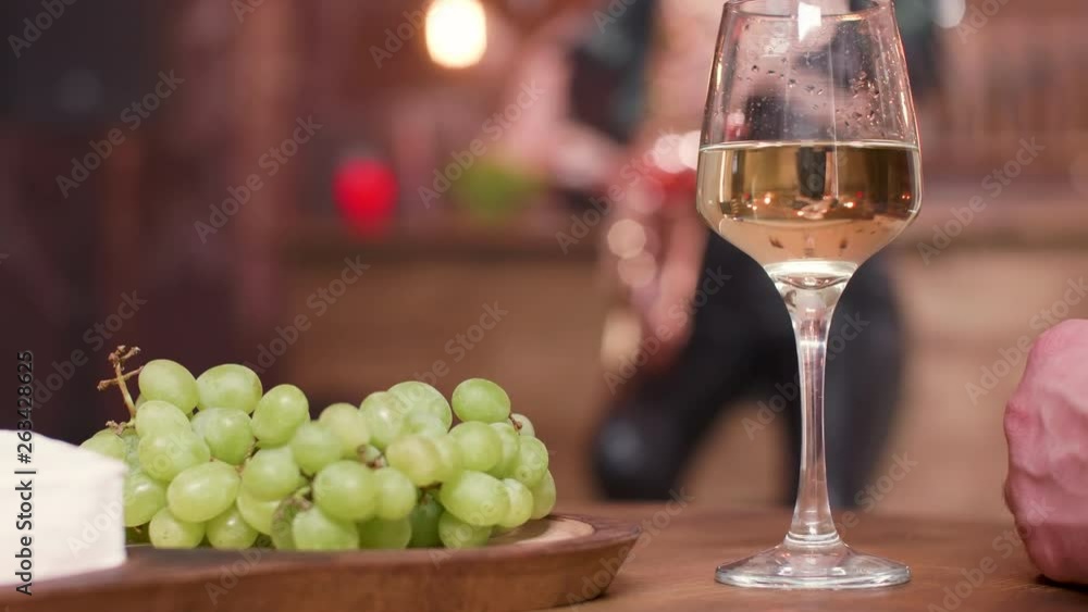 A glass of white wine and grapes on a wooden table. Appetizers on a restaurant table. A glass of white wine and grapes on a wooden table. Appetizers on a restaurant table.