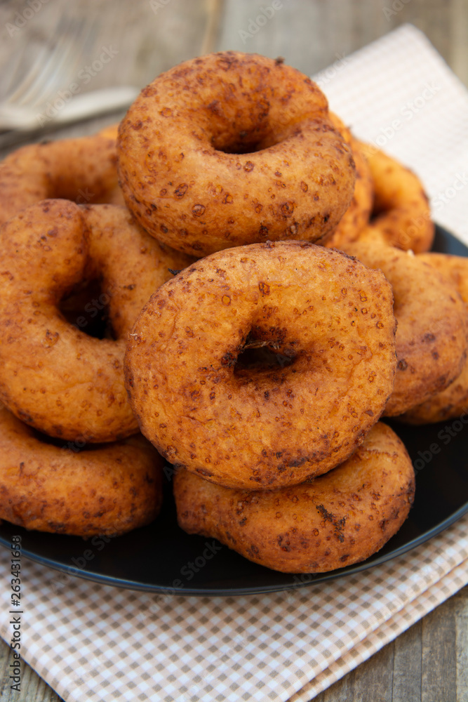 Homemade donuts. round, circle delicious donuts in black plate, wooden background. Isolated dessert or breakfast. Homemade donuts. round, circle delicious donuts in black plate, wooden background. Isolated dessert or breakfast.