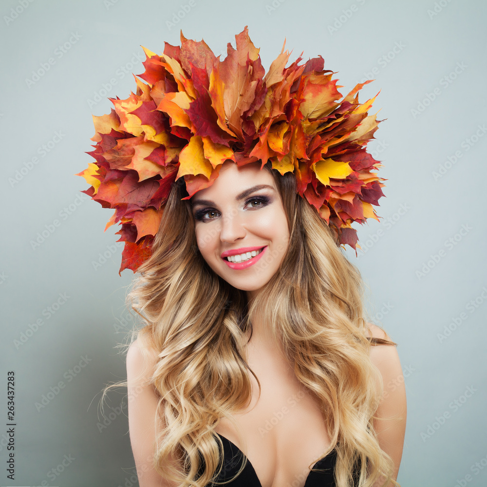 Cute cheerful woman in autumn leaves. Beautiful model face with make up and curly haircut portrait Cute cheerful woman in autumn leaves. Beautiful model face with make up and curly haircut portrait