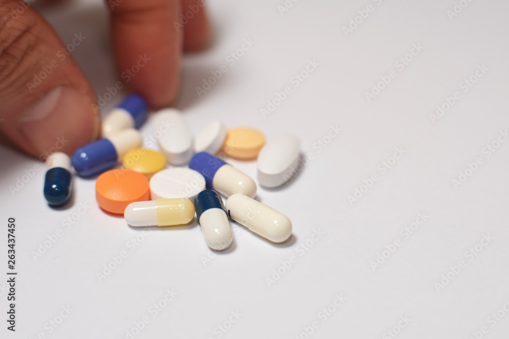 Various medical pills and capsules picked up with hand Various medical pills and capsules picked up with hand