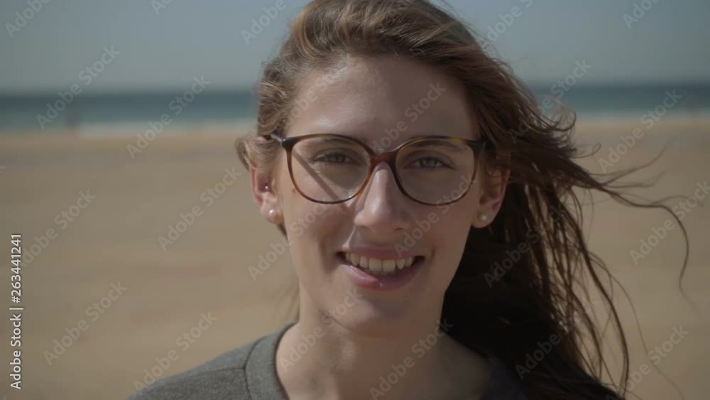 Closeup shot of smiling young woman in eyeglasses. Happy attractive lady posing during windy day. Happiness concept Closeup shot of smiling young woman in eyeglasses. Happy attractive lady posing during windy day. Happiness concept