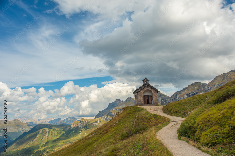 Mountain landscape with trail, green meadow and refudjio, Passo Pordoi, Dolomite Alps, Italy