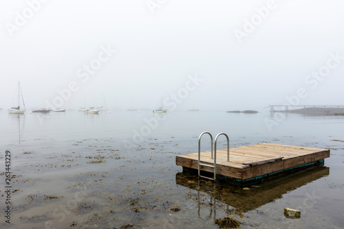 boats at anchor with raft in fog