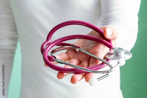 The doctor holds out the phonendoscope in his hand. Medical care concept.