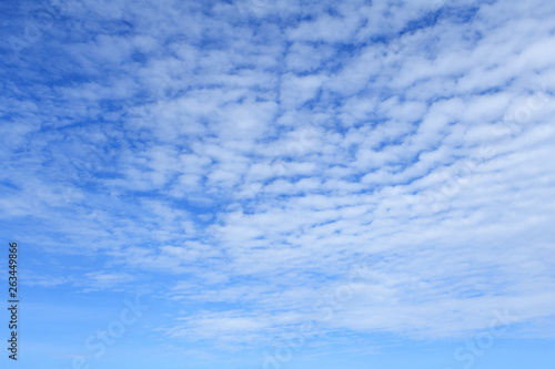 White clouds in bright blue sky as background