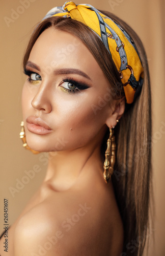 Photo sensual girl with dark hair and evening makeup, with silk headband
