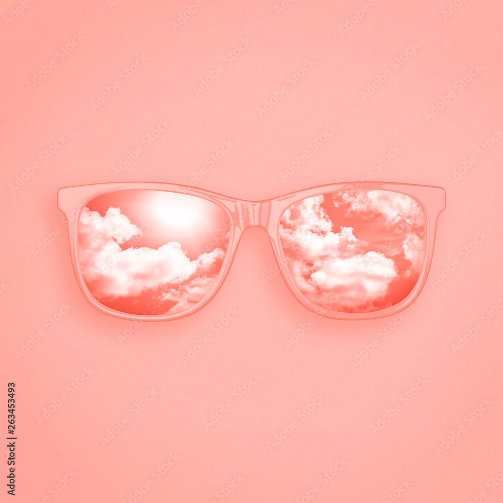 Creative layout made of sunglasses with reflection sky and cloud on pastel  coral color background. Summer concept. Sunglasses mockup as design element  vacation and journeys top view. Minimal concept Stock Photo