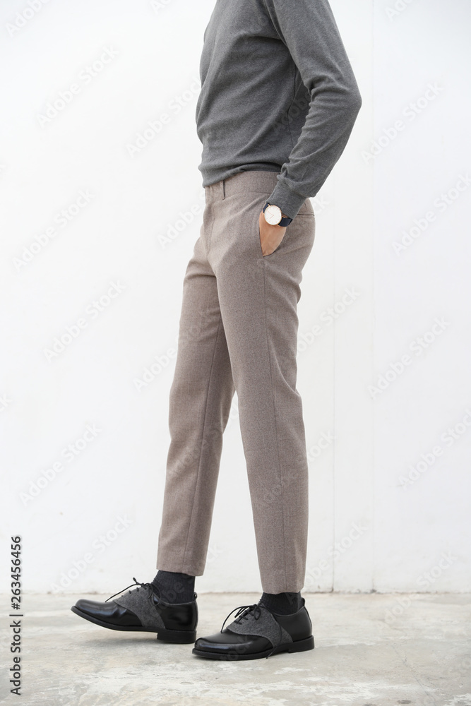 close-up of A handsome man in gray turtleneck shirt and long trousers on white background. close-up of A handsome man in gray turtleneck shirt and long trousers on white background.