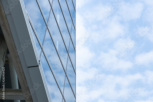 Cloud reflected on blue glass windows of building, Divided in half the building and the sky.