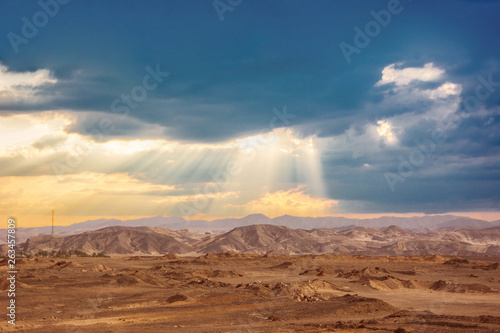 Sun lights in rainy clouds in egyptian desert