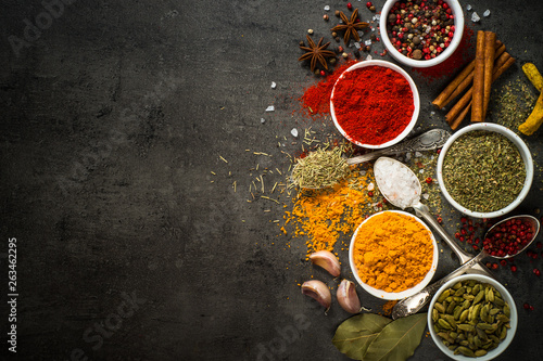 Set of various spices on black background.
