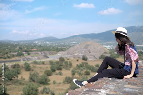 Asian girl at the cliff with pyramid background in Mexico © Phornarpha