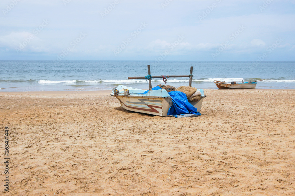 blue fishing boat on empty beach in Sri Lanka blue fishing boat on empty beach in Sri Lanka