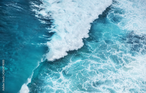 Waves and azure water as a background. View from high rock at the ocean surface. Natural summer seascape. Water background.