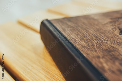 A book made of wood and leather, a wooden book with leather binding. Photobook with a cover made of genuine leather. Brown color with openwork embossing.