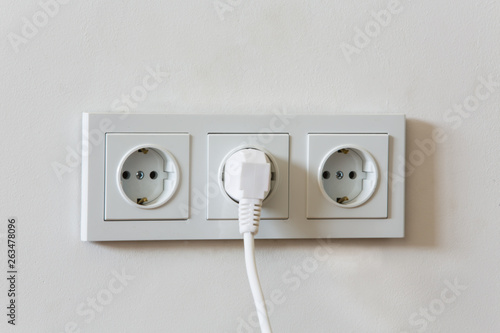 The electrical plug inserted into the electric socket