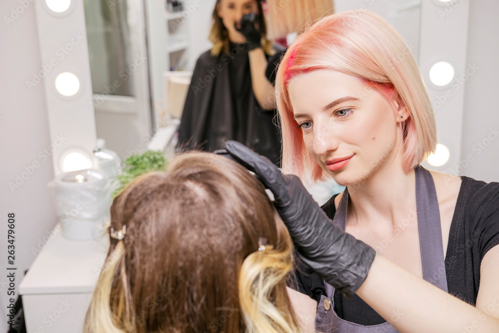 Brow and make up artist shaping and coloring eyebrows of her woman client in salon. Procedure in process. Space for text Brow and make up artist shaping and coloring eyebrows of her woman client in salon. Procedure in process. Space for text