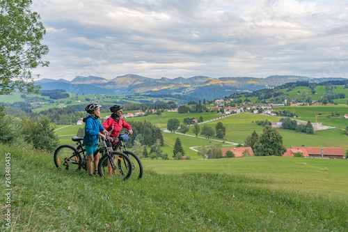 young happy grandmother and her grandson underway with their Mountainbikes in the Allgaeu Alps near Oberstaufen, bavarian Alps, Germany