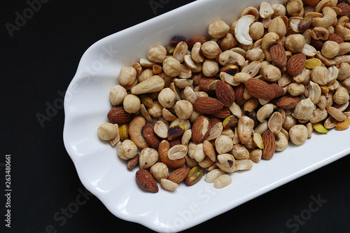 nuts, cashew nuts, dry almonds all close up on a plate, dry foods on black ground, nuts,