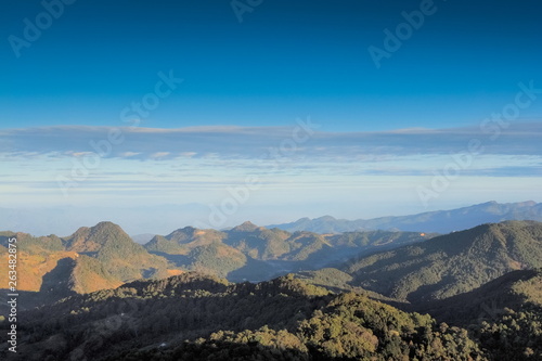Mountain view morning of top hills around with soft fog and blue sky background, sunrise at top view point highest of Doi Ang Khang, Chiang Mai, northern of Thailand. © Yuttana Joe