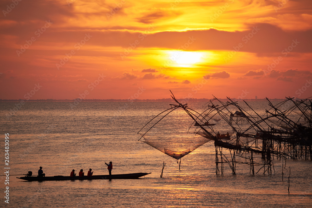Tourists on the long tail boat taking photography of net fishing during sunrise in the morning