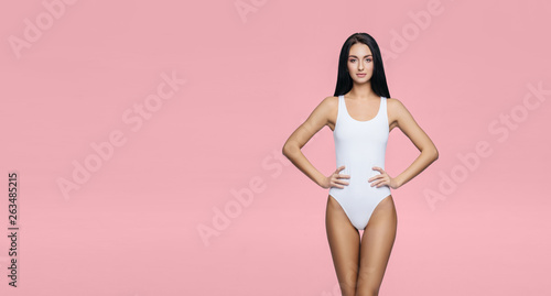 Fototapeta Naklejka Na Ścianę i Meble -  Fit and sporty girl in underwear. Beautiful and healthy woman posing in white swimsuit. Slim body. Sport, fitness, diet, weight loss and healthcare concept.