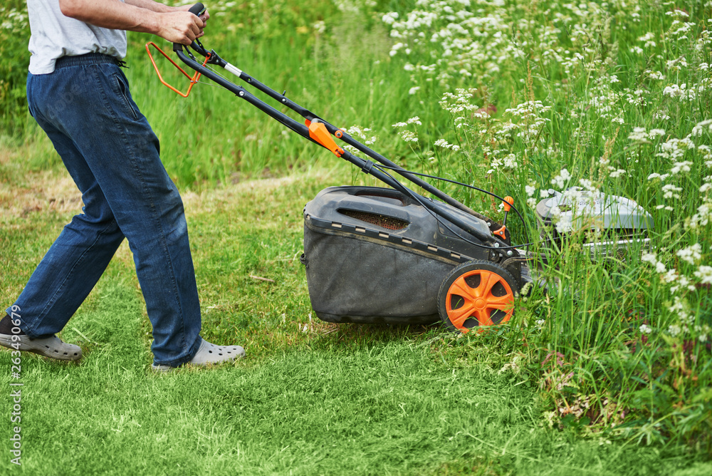Man is using lawn mower on his countryside yard. Man is using lawn mower on his countryside yard.