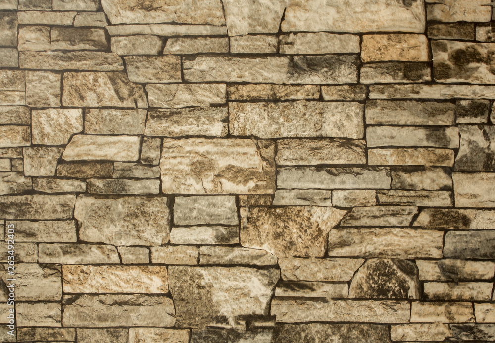 gray brown stone wall of bricks of various shapes and sizes. rough surface texture