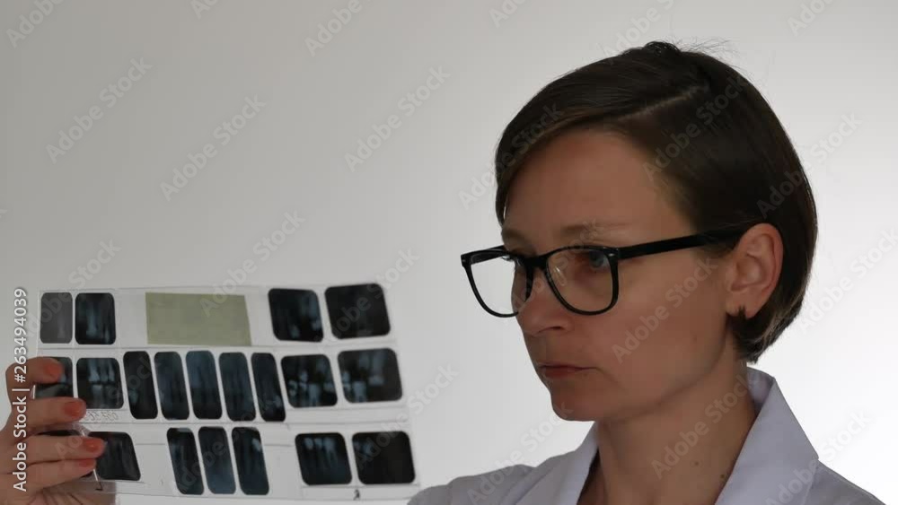 Dentist looks x-ray picture of teeth. Dentist looks x-ray picture of teeth.