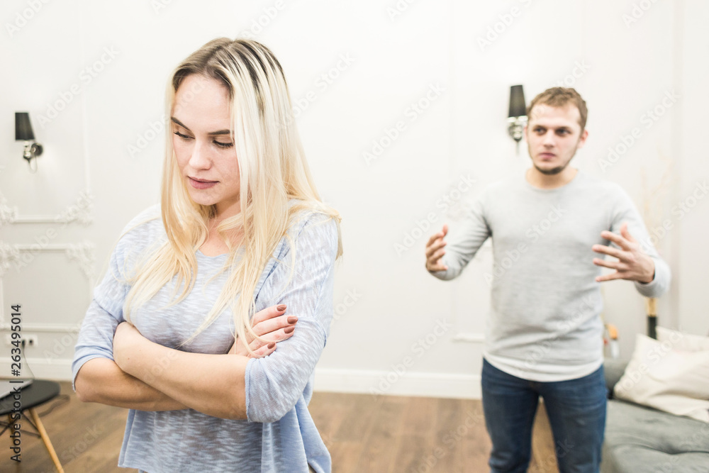 Unhappy young couple quarreling in the living room. Unhappy young couple quarreling in the living room.