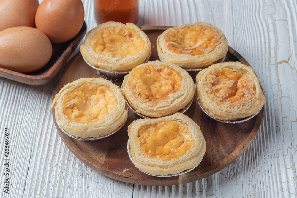 close up of egg tarts on wooden plate close up of egg tarts on wooden plate