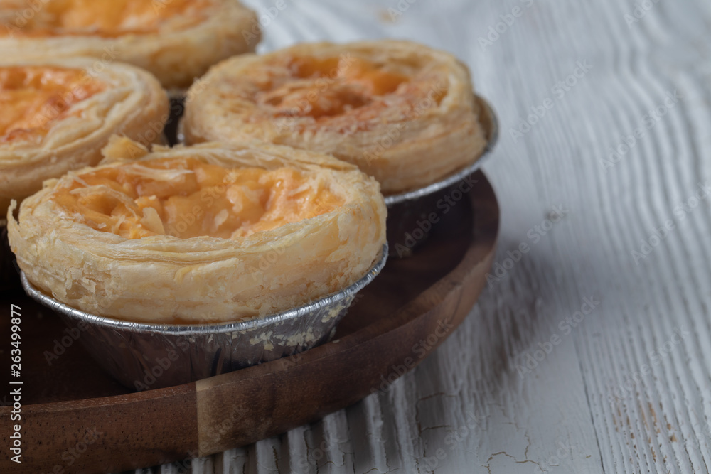close up of egg tarts on wooden plate close up of egg tarts on wooden plate