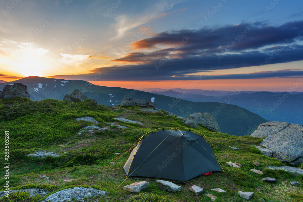 Rest on the mountain valleys in tourist tents with fantastic views on the snow-capped peaks of Ukrainian Carpathians.