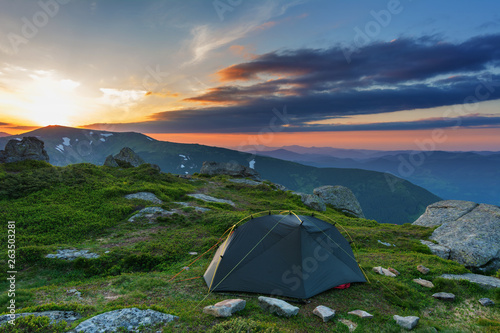 Rest on the mountain valleys in tourist tents with fantastic views on the snow-capped peaks of Ukrainian Carpathians.