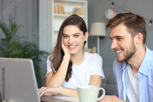 Couple pointing while working together on laptop.