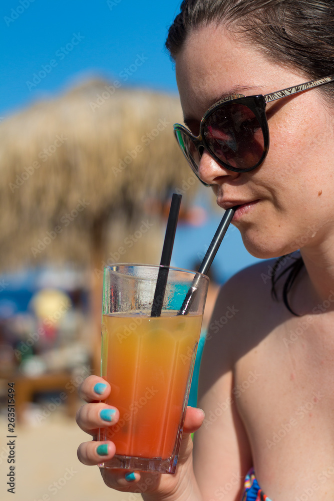 Woman drinking cocktail side portrait Woman drinking cocktail side portrait