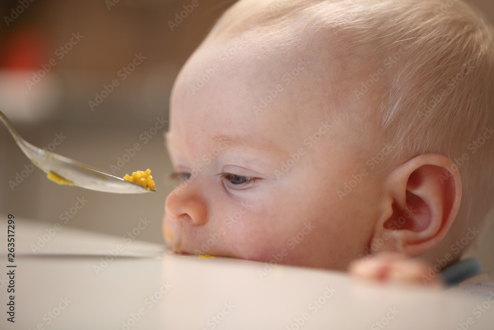 A child of 6 months pedagogical feeding from a spoon of porridge. A child of 6 months pedagogical feeding from a spoon of porridge.