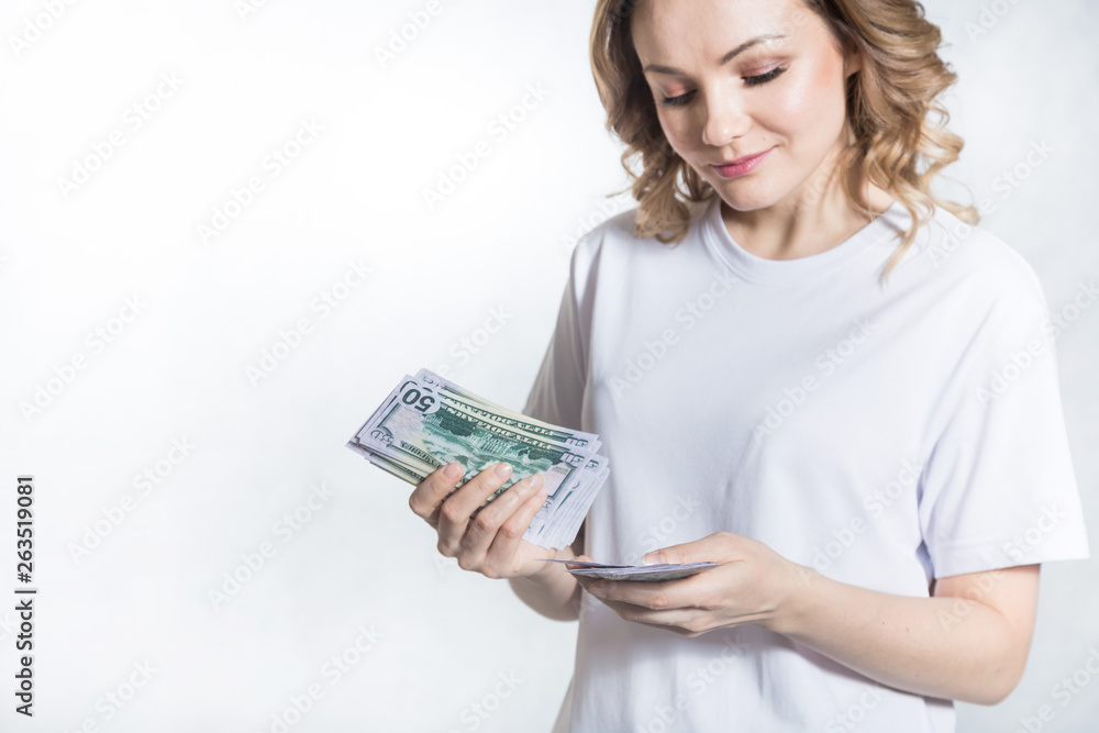 Pensive young woman counts us dollar money over white background. Pensive young woman counts us dollar money over white background.