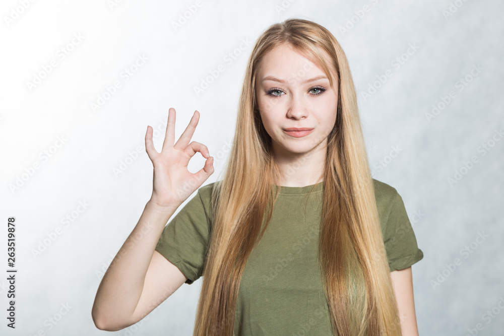 Fototapeta premium Young beautiful woman shows ok sign. Body language concept.